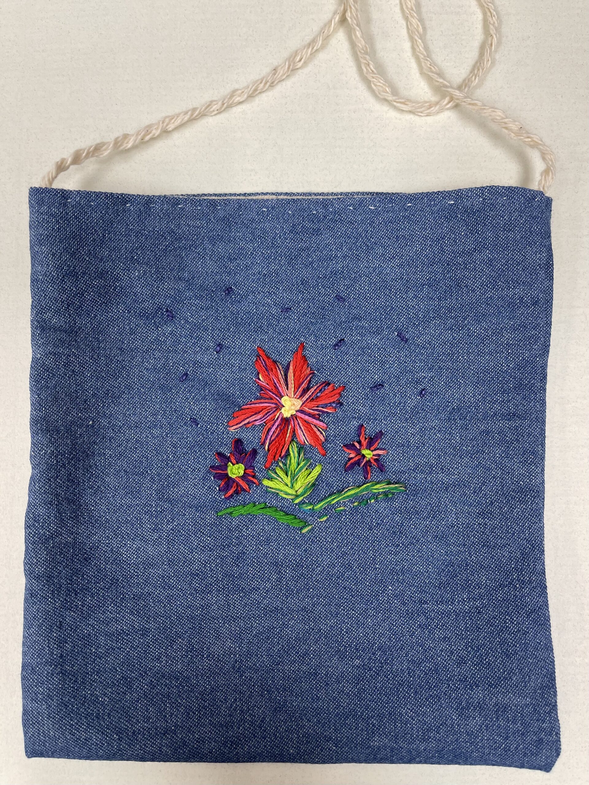 navy blue bag with an embroiered red and purple flower